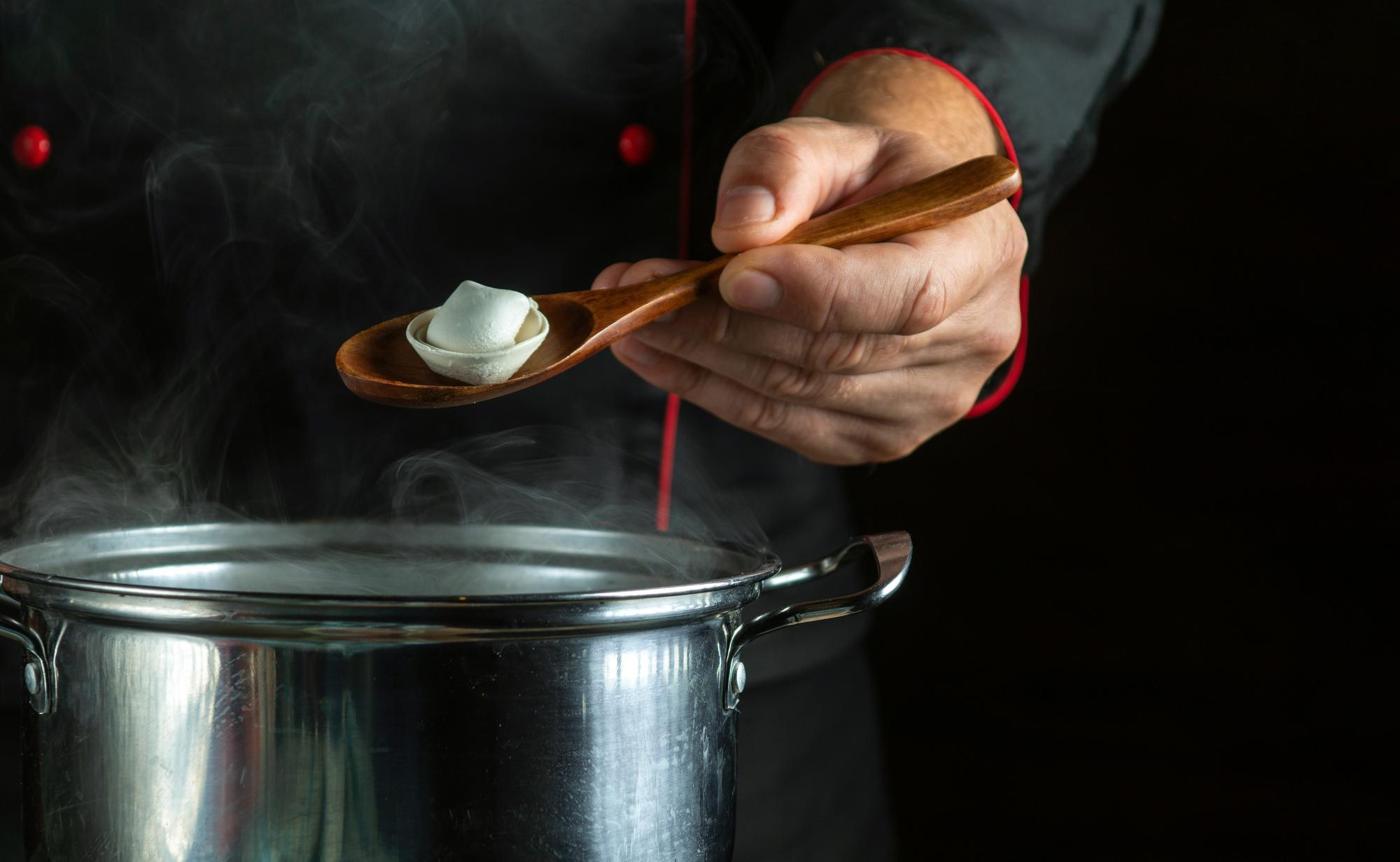 chef hand finishing a sauce with tweezers