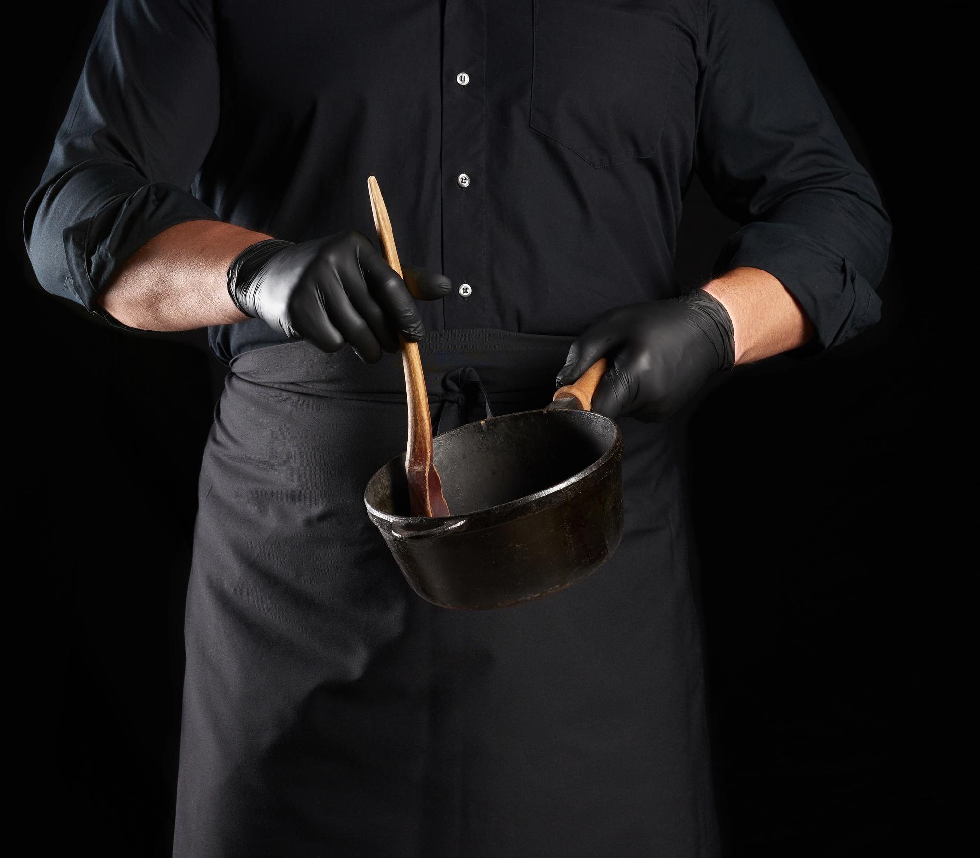 chef arranging plated tasting menu on dark marble